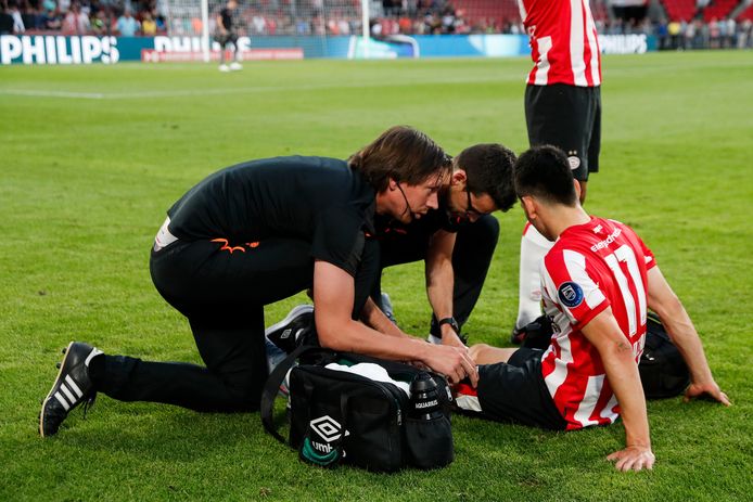 Hirving Lozano wordt in de slotfase van PSV-VfL Wolfsburg behandeld door de medische staf van PSV.