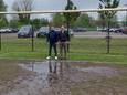Jeugdtrainer Kris Hinssen en gemeenteraadslid Koen Van Ootegem op de modderige voetbalsite in Assenede.