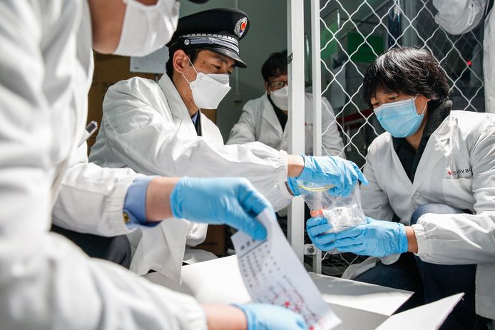 Medewerkers van de gezondheidsdienst inspecteren stalen in Peking.