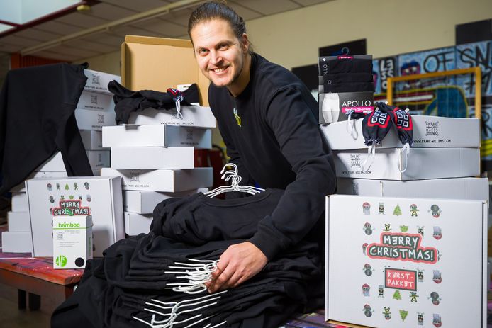 Kunstenaar Frank Willems met de kleding-kerstpakketten voor dak- en thuislozen.