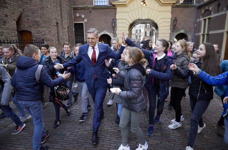 Buma (CDA) deelt tegelijkertijd een hand én een high five uit aan scholieren. Beeld anp