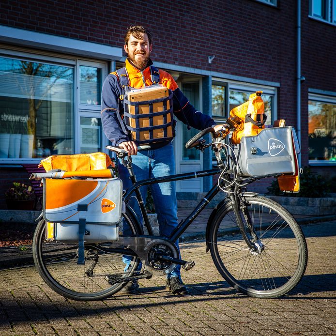 Postbode Gijs Huppertz doet zijn vertrouwde bezorgronde in Strijen. ,,Het leukste van mijn baan is dat je een beetje een bekend gezicht bent en dat je betrokkenheid kan tonen doordat je met mensen in contact staat.”