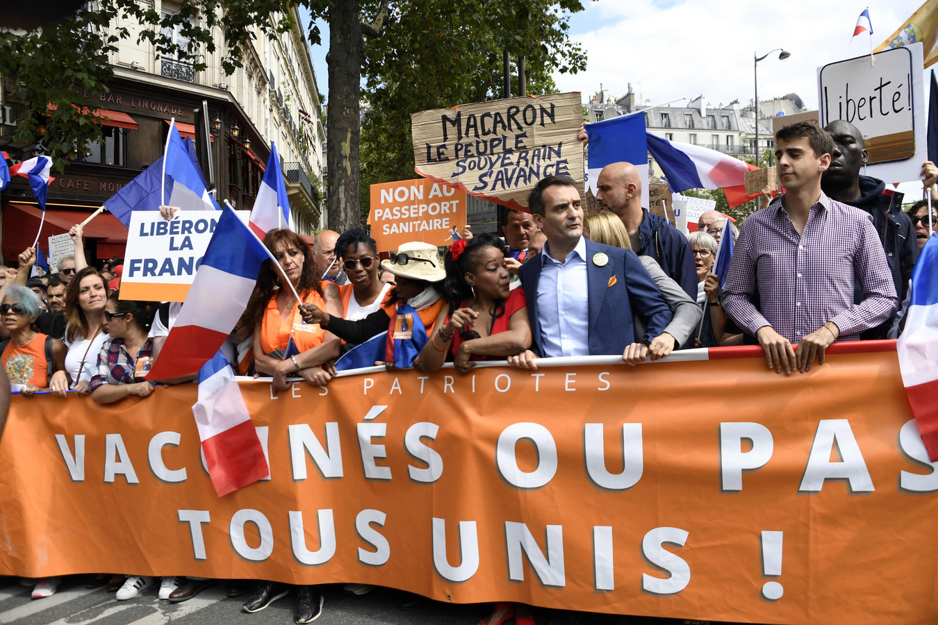 Le leader du parti nationaliste français "Les Patriotes", Florian Philippot, défile avec une banderole lors d'une manifestation dans le cadre d'une journée nationale de protestation contre la législation française rendant obligatoire le carnet de santé Covid-19 pour se rendre dans un café, monter dans un avion ou voyager dans un train interurbain, à Paris le 31 juillet 2021.