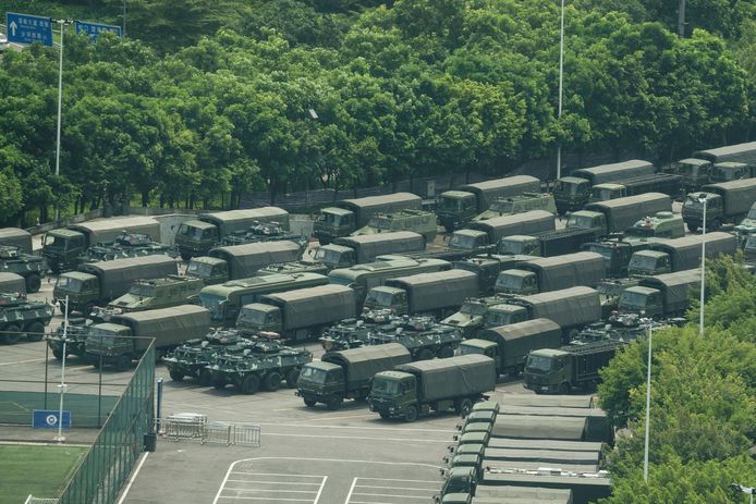 Tientallen voertuigen van het Chinese leger verzamelen aan een stadion nabij Hongkong.