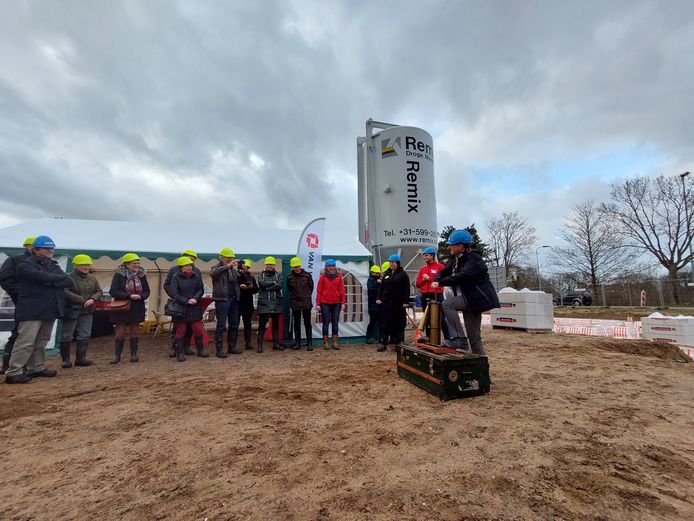 De start van de bouw van project De Havenmeester in Doesburg: wethouder Birgit van Veldhuizen pompt lucht in een oude scheepshoorn die vervolgens toetert. De hoorn is een verwijzing naar de boten die enkele meters verderop voorbij varen.
