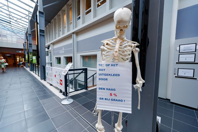 Een skelet als symbool voor ziekenhuispersoneel dat ‘tot op het bot is uitgekleed’.