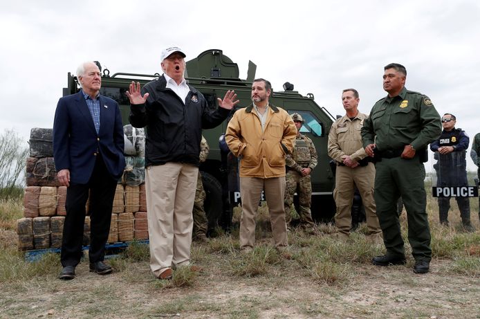 President Donald Trump aan de zuidelijke grens in Texas samen met de Republikeinse senatoren John Cornyn (links) en Ted Cruz uit Texas en enkele Amerikaanse grenspolitieagenten.