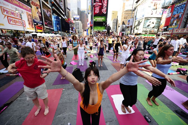 Juni 2010: zwaaien en strekken tijdens een massale yoga-sessie op Times Square in New York City. Beeld AFP