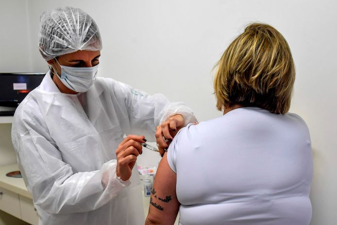 Een proefpersoon krijgt het kandidaat-vaccin van AstraZeneca toegediend in Brazilië