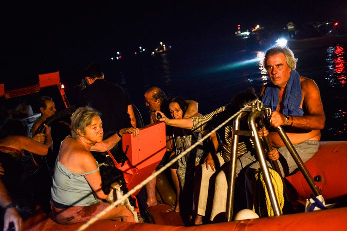 Reddingspersoneel en dorpelingen worden per boot geëvacueerd vanuit Mati.
