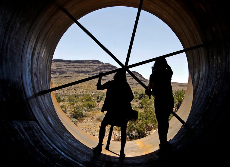 Mensen lopen door een tentoongesteld stuk tunnelbuis van de hyperloop. Beeld afp