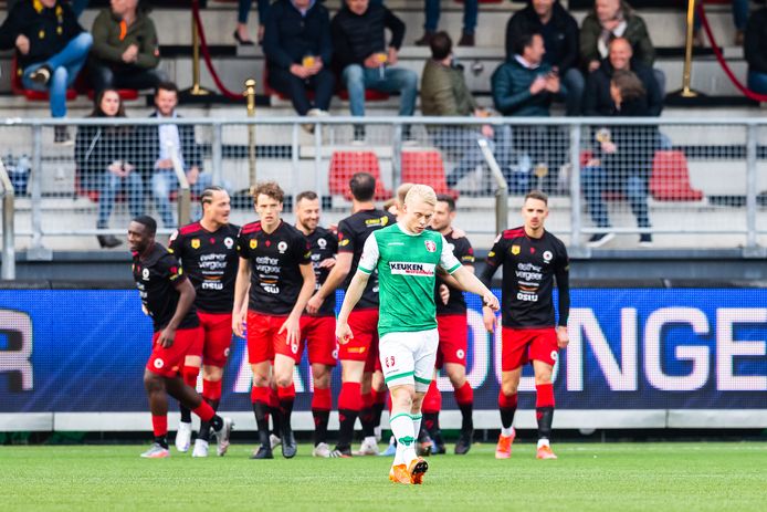 FC Dordrecht-verdediger Thomas Poll verbijt zijn teleurstelling, terwijl Excelsior een doelpunt viert.