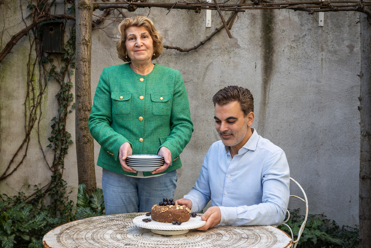 Moeder Smuni Turan en zoon Matay de Mayee met op tafel qawité, een taart die wordt gegeten na drie dagen vasten. Turan: ‘Hij smaakt zoals die van mijn moeder.’ Beeld Dingena Mol