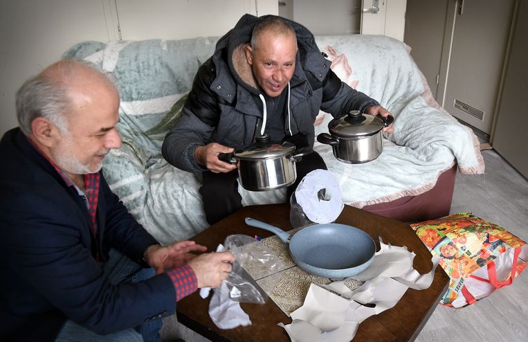 Mohammed krijgt van zijn begeleider Nihat Kahveci drie pannen voor zijn nieuwe woning. Beeld Marcel van den Bergh  / de Volkskrant