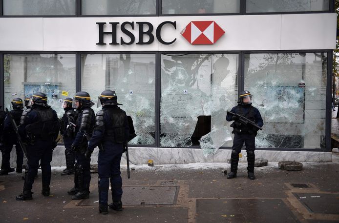 Oproerpolitie bij een kantoor van de bank HSBC waar de ramen werden ingeslagen.