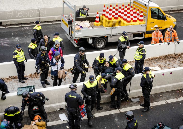 De politie grijpt in tijdens de demonstratie van klimaatactiegroep Extinction Rebellion bij de A12 tussen het ministerie van Economische Zaken en Klimaat en de tijdelijke Tweede Kamer. Beeld ANP
