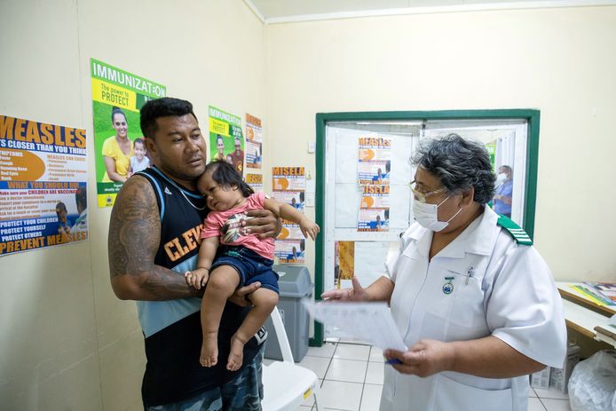 Een vader brengt zijn kind naar het ziekenhuis in Samoa.