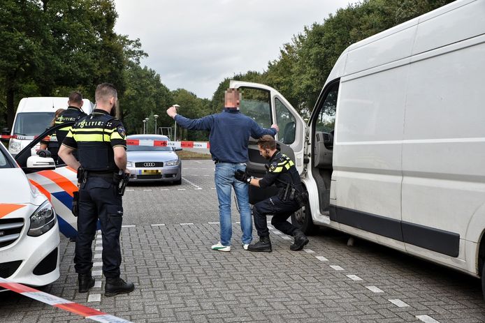De politie doet onderzoek bij de witte bus met drugsvaten in Berkel-Enschot.