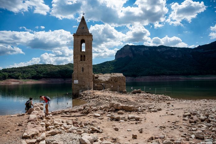 Mensen bekijken de ruïnes van de 'verdronken kerk' in de provincie Girona.