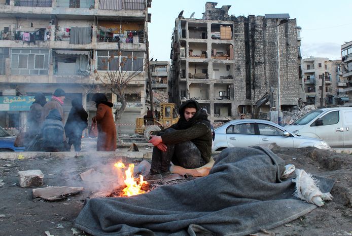 Inwoners van de Syrische stad Aleppo leven op straat en warmen zich in de vrieskou aan een vuurtje.