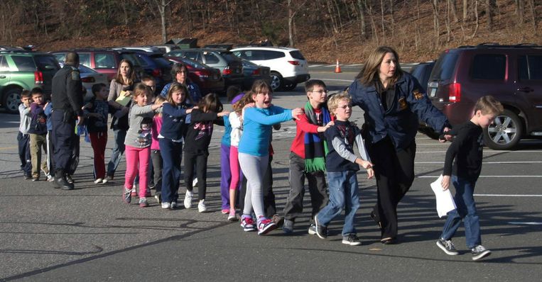 Politie begeleidt leerlingen van de Sandy Hook Elementary School in Newtown naar buiten na een schietpartij, 14 december 2012. Beeld ap