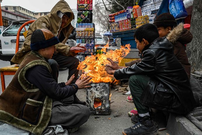 Afghaanse kinderen warmen zich op straat aan een vuurtje in de hoofdstad Kaboel.