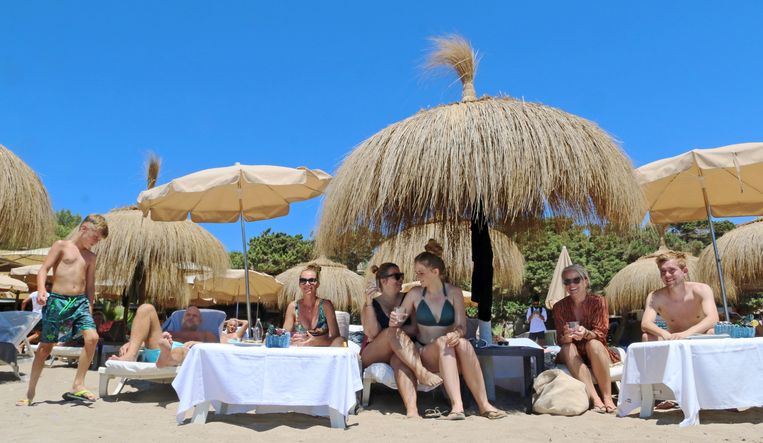 Het eiland Ibiza is de laatste jaren enorm populair geworden onder Nederlanders. Bij de beachclub Tropicana komen veel landgenoten, zoals de achtjarige Stef met zijn moeder Tirza de Bruyn (derde van links) en een groep vrienden. Beeld Edwin Winkels