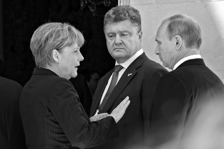 Met de Oekraïense president Petro Porosjenko en de Russische president Vladimir Poetin, juni 2014.
(Foto uit het boek Angela Merkel. De kanselier en haar tijd) Beeld picture alliance / dpa