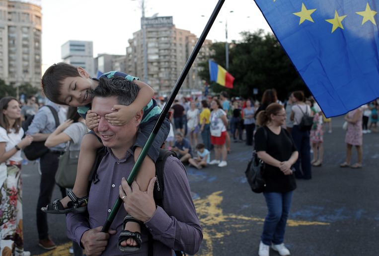 Een man met een vlag van de Europese Unie doet mee aan een protest tegen corruptie in Roemenië, augustus in de hoofdstad Boekarest. Beeld EPA