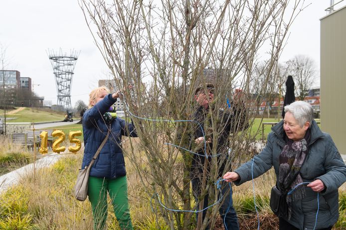 Tilburg - Pix4Profs/René Schotanus. Vanwege het 125-jarig bestaan biedt Groei&Bloei een boom aan die in het Spoorpark komt. Ariane Verhoeven (L) en Ineke Sinnema (R) verwijderen de touwtjes.