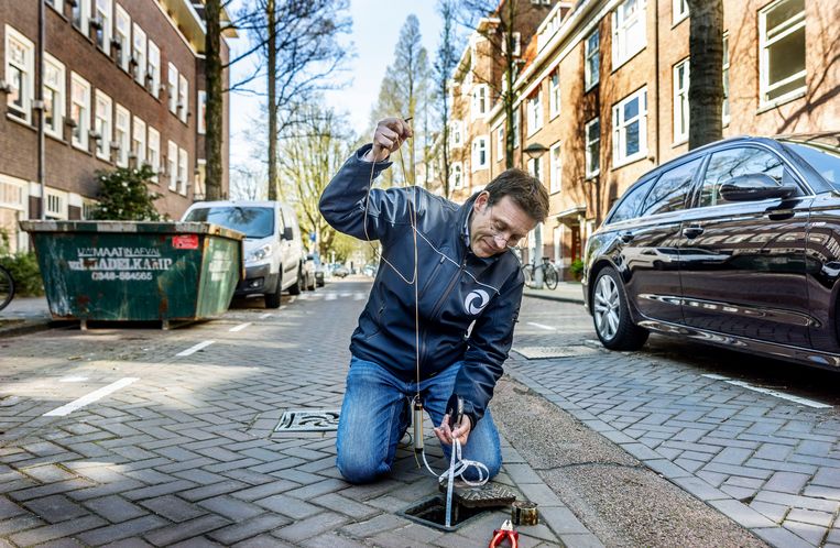 Hydroloog Frank Smits in de Amsterdamse Argonautenstraat bij een peilbuis om het grondwaterpeil te meten. Beeld Jean-Pierre Jans