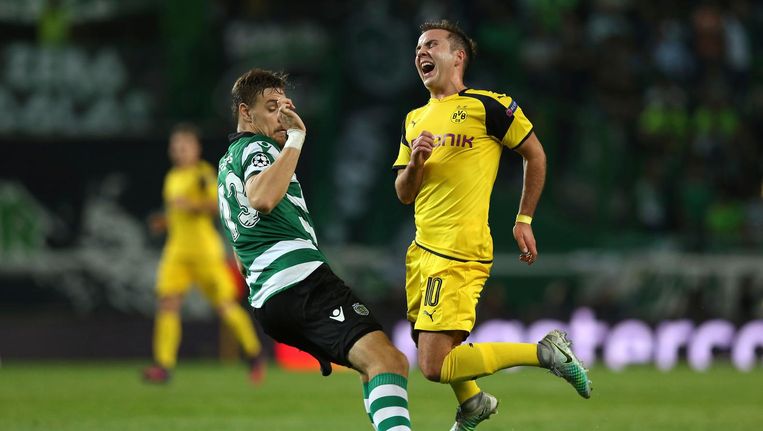 Mario Goetze van Dortmund valt na een duel met Sebastian Coates van Sporting. Beeld AP