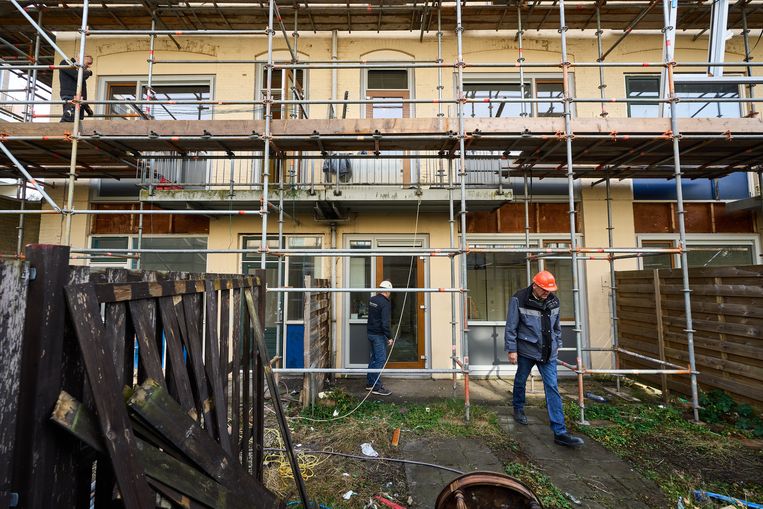 Een kozijn met dubbelglas wordt geplaatst in een sociale huurwoning in Den Haag.  Beeld ANP