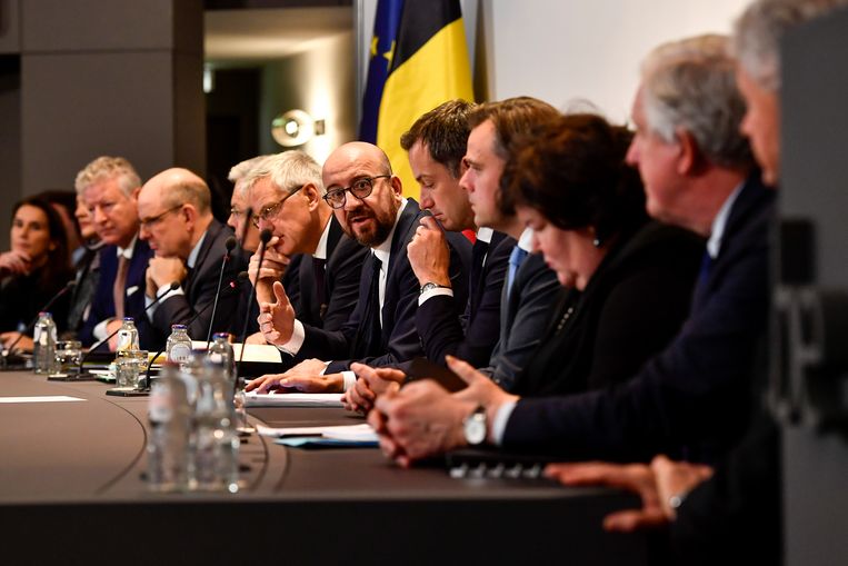 Persconferentie over migratie in België met in het midden premier Charles Michel. 
 Beeld BELGA / Dirk Waem 