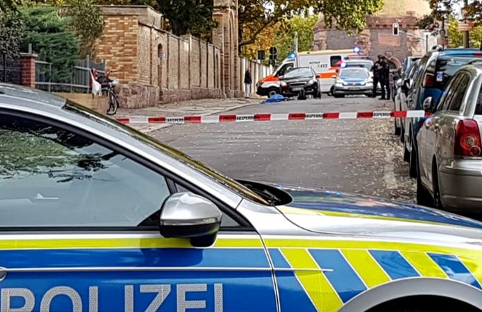 De plek waar de schietpartij plaatsvond in Halle. Voor de synagoge ligt een slachtoffer, bedekt met een blauw laken.