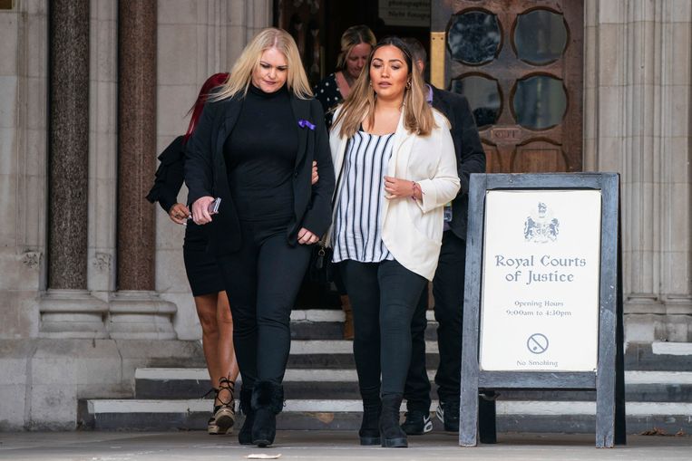 De moeder van de Britse jongen Archie (links) loopt de rechtbank in Londen uit.  Beeld AP