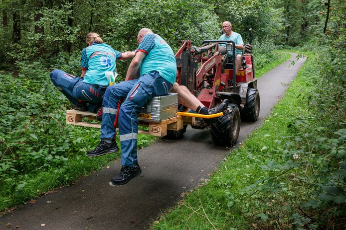 Boer Diederik Groen brengt per shovel de gewonde man naar de ambulance, samen met het ambulancepersoneel.