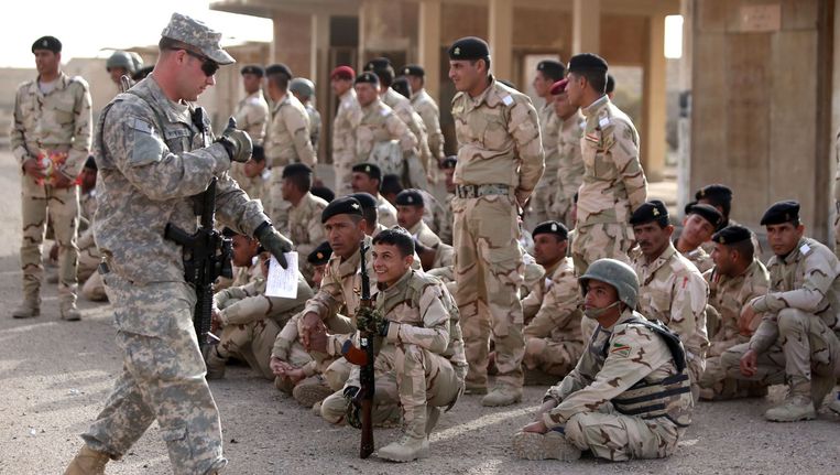 Een Amerikaanse instructeur geeft training aan Iraakse militairen. Beeld afp