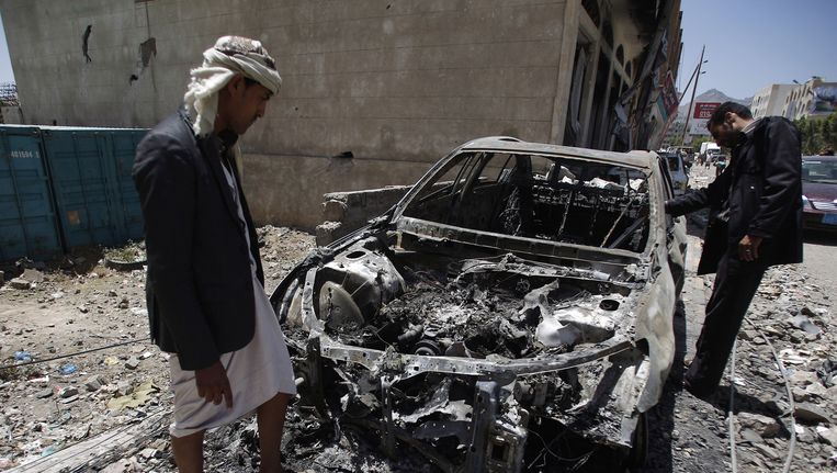 Inwoners van Sanaa maken de schade op na een bombardement van Saoedische vliegtuigen. Beeld ap