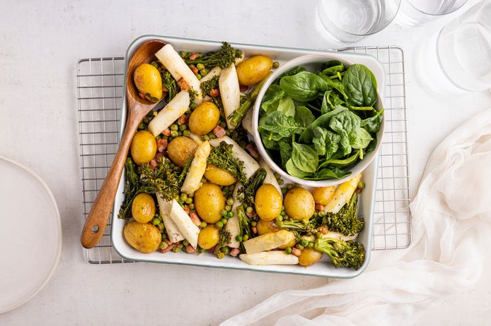 Witte asperges uit de oven met uitgebakken pancetta, doperwten en krieltjes.
