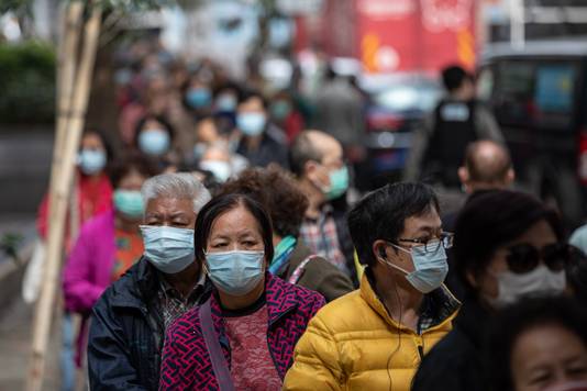 Mensen in de rij om mondmaskers te ontvangen in Hong Kong.