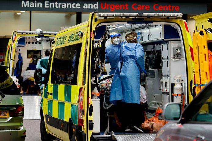 Zorgmedewerkers met coronapatiënten in ambulances aan een ziekenhuis in Londen.
