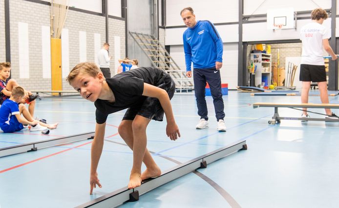 Julian Kuipers van de Martinusschool, achterwaarts op de balk, onder toeziend ook van bewegingscoach Jurgen Schiphorst.