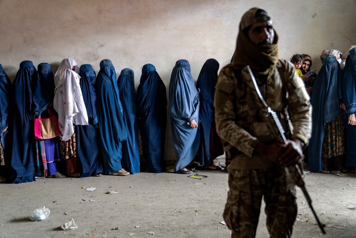 Vrouwen worden bewaakt door de Taliban tijdens het wachten op voedselpakketten die worden uitgedeeld door een hulporganisatie in Kabul, Afghanistan.