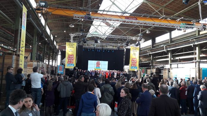 De afspraken zijn ondertekend. Alle ondertekenaars staan op het podium.