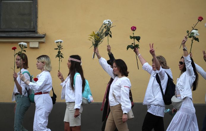 Vrouwen met bloemen in de hand vragen de vrijlating van opgepakte betogers in Minsk.
