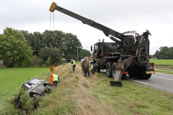 Een takelwagen van Defensie haalt de terreinwagen - ook van Defensie - uit de sloot.