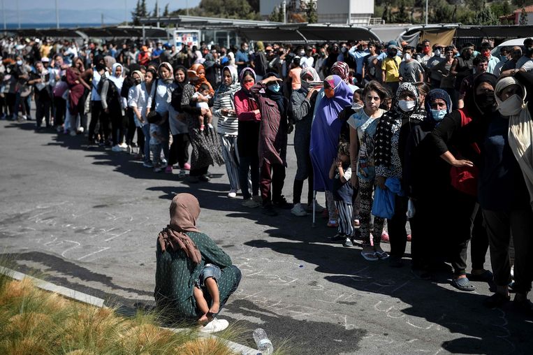 Migranten op Lesbos staan donderdag in de rij voor voedsel en water nadat een brand vluchtelingenkamp Moria verwoestte. Beeld AFP