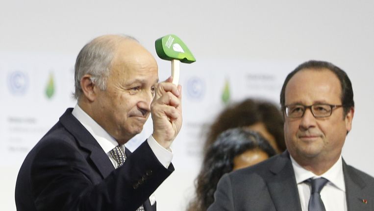 Hollande (R) kijkt toe hoe COP21-voorzitter Fabius het klimaatakkoord afhamert. Beeld anp