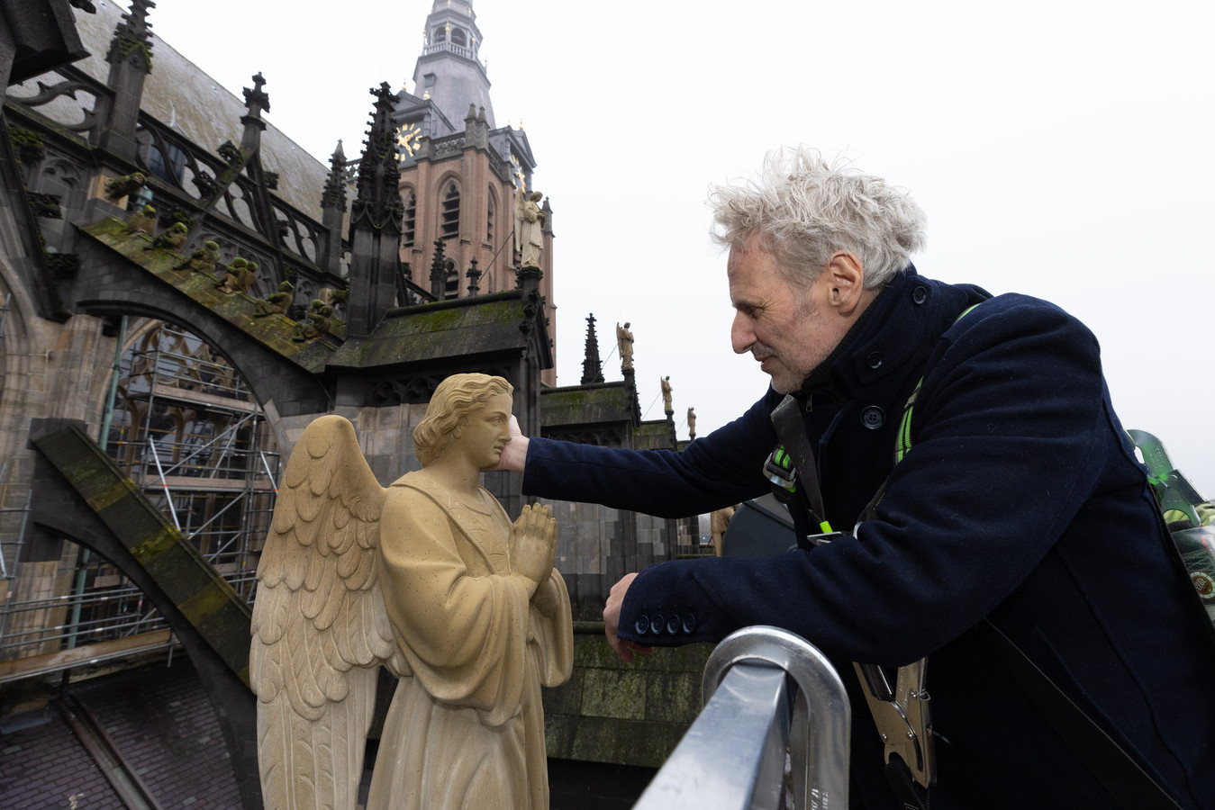 Nog een laatste aai  van beeldhouwer Van Druten voor een van zijn beelden op de Sint-Jan.